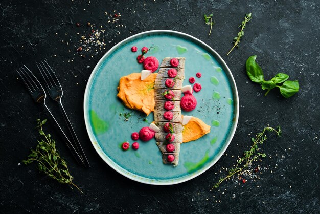 Filete de arenque salado con salsa en un plato Vista superior Estilo rústico