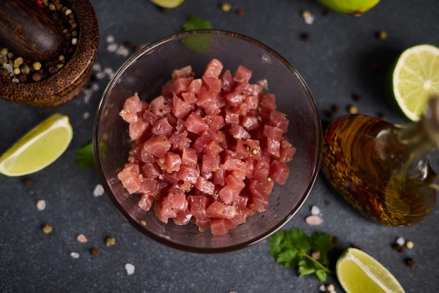 Foto filete de atún cortado y picado en un cuenco de vidrio en la cocina doméstica cocinando tartaro tradicional