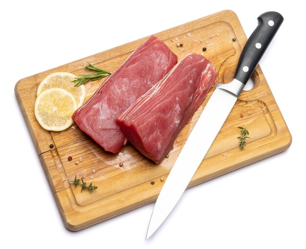 Un filete de atún fresco en una tabla de corte de madera aislada sobre un fondo blanco