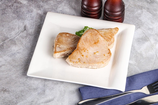 Un filete de atún rojo asado en el plato.