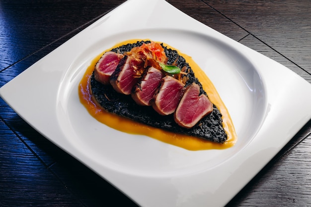 Filete de atún tataki con risotto negro y salsa de mango