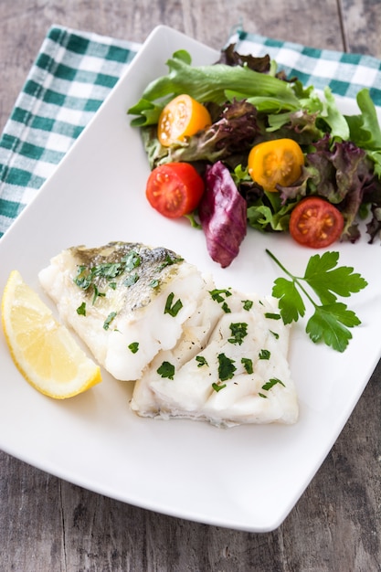 Filete de bacalao frito y ensalada en plato