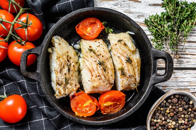 Filete de bacalao frito con especias en una sartén de hierro fundido