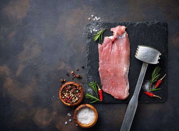 Filete de carne cruda con especias sobre fondo oxidado