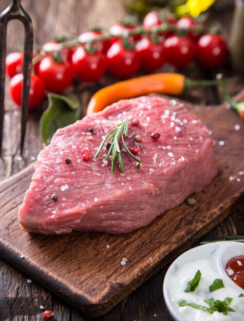 Un filete de carne cruda en una mesa de madera