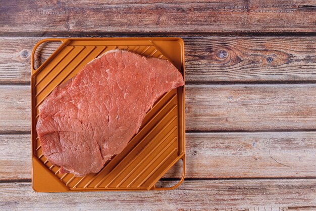 Filete de carne cruda roja orgánica en una tabla de madera.