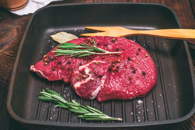 Filete de carne cruda en una sartén de cuarto de galón negro