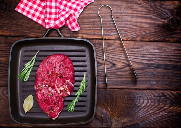 Filete de carne cruda en una sartén de cuarto de galón negro