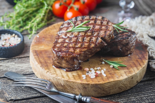 Filete de carne marmoleado a la plancha Filet Mignon con condimentos. Filete de ternera jugoso en la tabla de cortar.