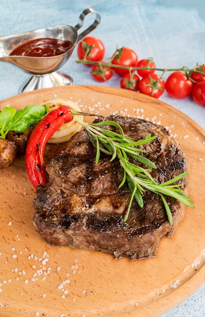 Filete de carne a la parrilla sobre una tabla con verduras