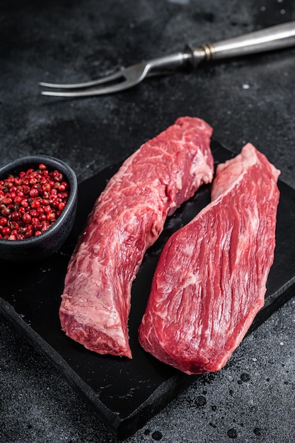 Filete de carne de res cruda de Bavette o solapa de solomillo en tablero de mármol Fondo negro Vista superior