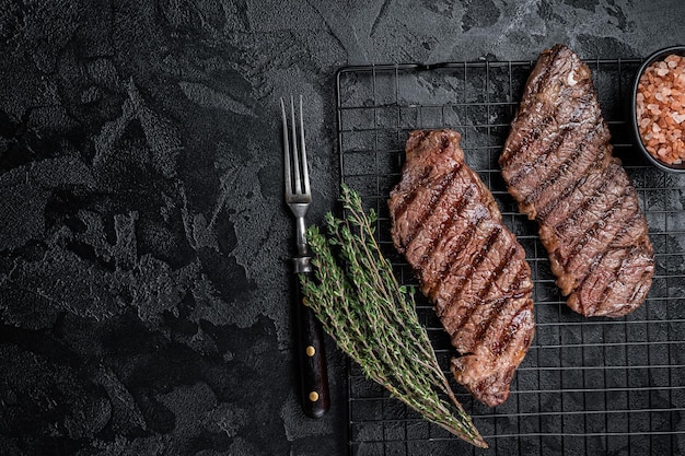 Filete de carne de res de denver a la parrilla en un estante Fondo negro Vista superior Espacio de copia