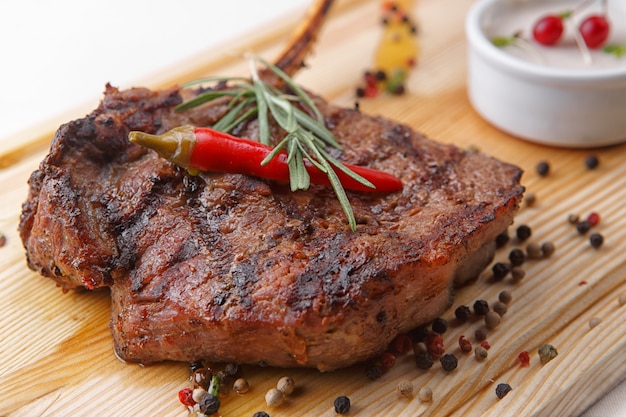 Filete de carne con salsa sobre una tabla de madera