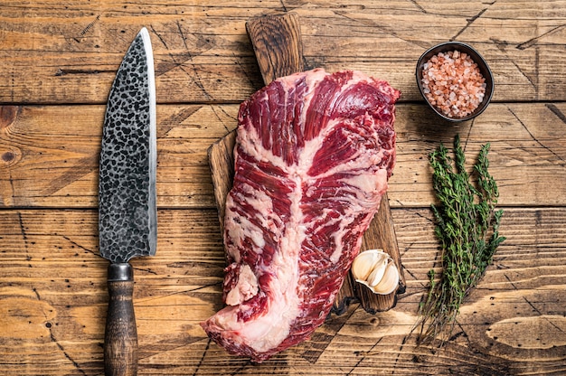 Filete de carne de vacuno cruda Onglet o percha en tablero de carnicero con cuchillo. fondo de madera. Vista superior.