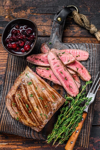 Filete de carne de vacuno de flanco en rodajas de barbacoa sobre una tabla de cortar de madera