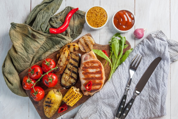 Foto filete de cerdo frito y verduras a la parrilla, deliciosa cena barbacoa,