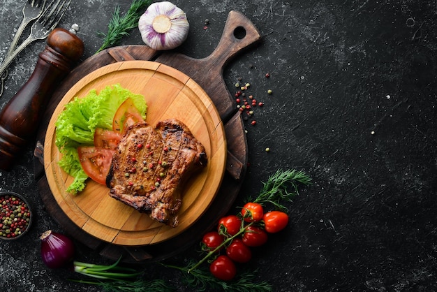 Filete de cerdo con hueso con verduras en el tablero Menú de barbacoa Vista superior