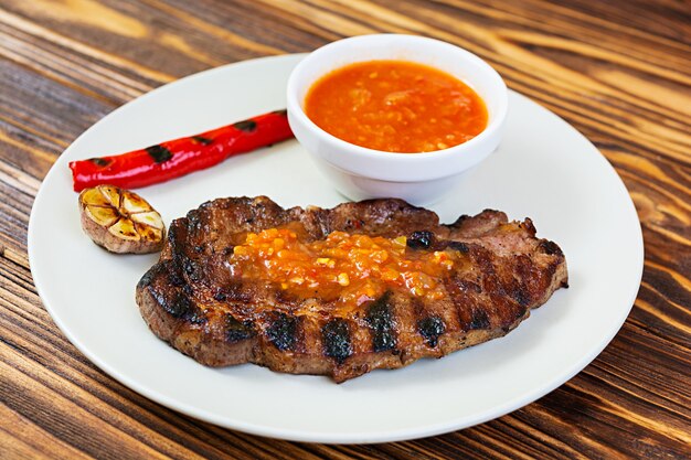 Filete de cerdo jugoso a la parrilla sobre mesa de madera.