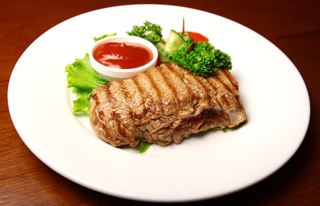 Filete de cerdo jugoso con salsa y verduras en un plato