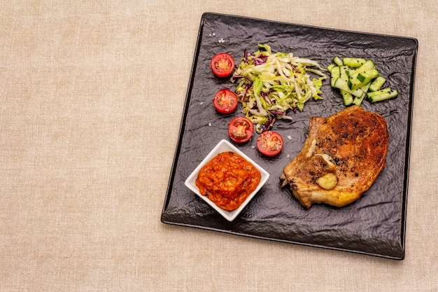 Filete de cerdo a la parrilla con salsa de tomate y ensalada de col