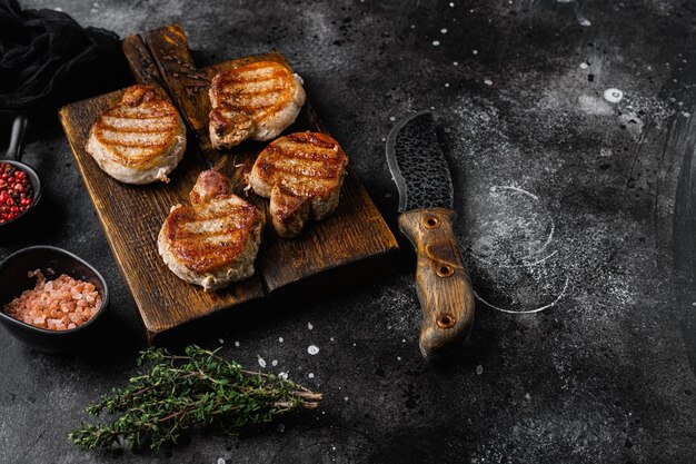 Filete de cerdo a la parrilla sobre fondo de mesa de piedra oscura negra con espacio para copiar texto