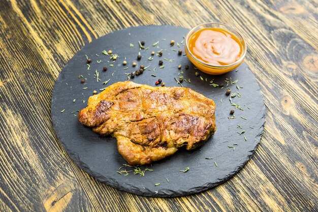 Foto filete de cerdo a la plancha sobre una mesa de madera.