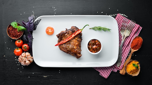 Filete de cerdo con salsa barbacoa En el plato Sobre un fondo de madera Vista superior Espacio libre para el texto