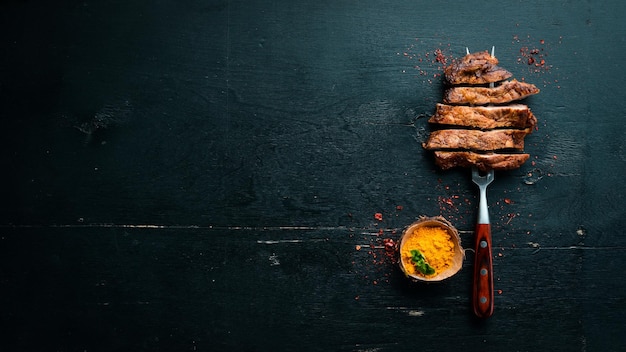 Filete de cerdo en el tenedor Sobre un fondo de madera Vista superior Espacio libre para el texto