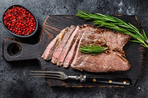 Filete de chuleta de carne de ternera a la plancha sobre una tabla para cortar. Vista superior.