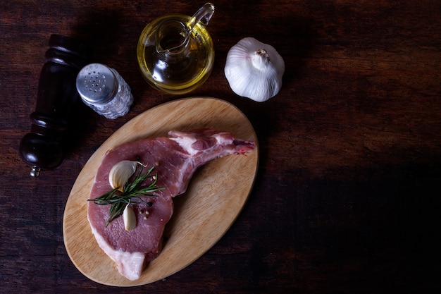 Filete de chuleta de cerdo crudo en un fondo de madera