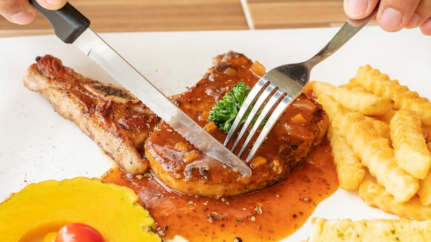 Filete de chuleta de cerdo en un plato blanco.