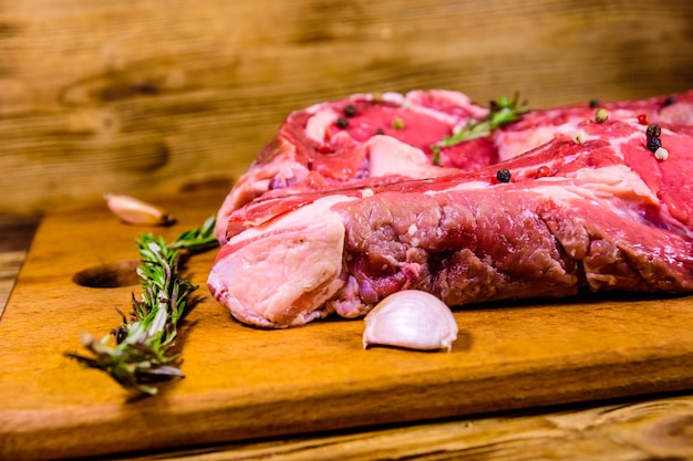 Filete de chuletón crudo especias romero y ajo en tabla de cortar