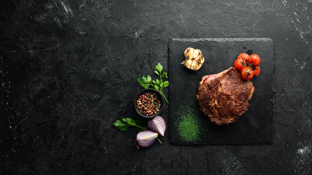 Foto filete de chuletón a la parrilla en el fondo antiguo vista superior espacio libre para el texto estilo rústico