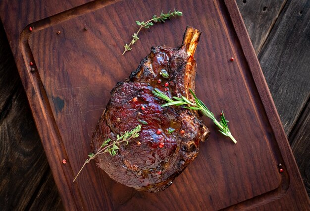 Filete de chuletón a la parrilla en huesos sobre tabla de madera, excelente filete de vaquero, vista desde arriba