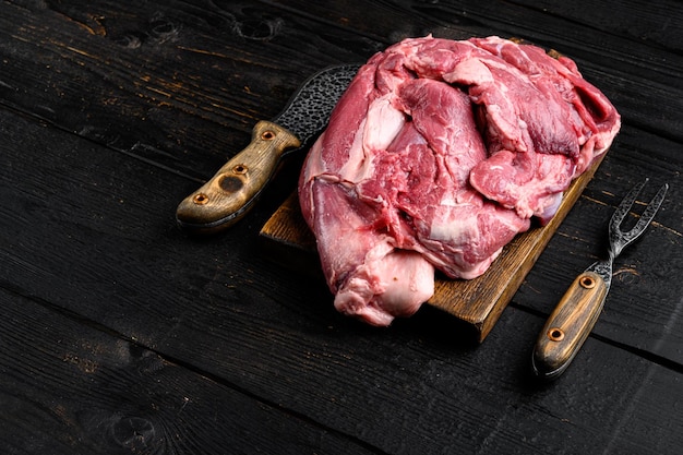 Filete de cordero crudo Carne orgánica fresca sobre fondo de mesa de madera negra con espacio para copiar texto