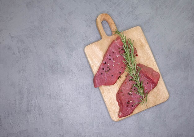 Filete de costilla fresca sobre tabla de cortar de madera