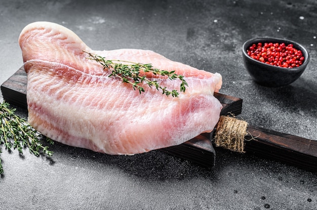 Filete crudo de bagre de pescado blanco sobre una tabla para cortar