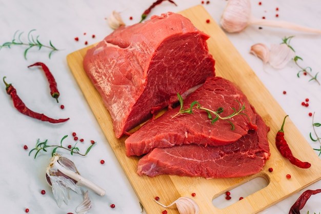 Filete crudo de cerdo fresco en el tablero de madera. Carne de res roja sobre una tabla para cortar.