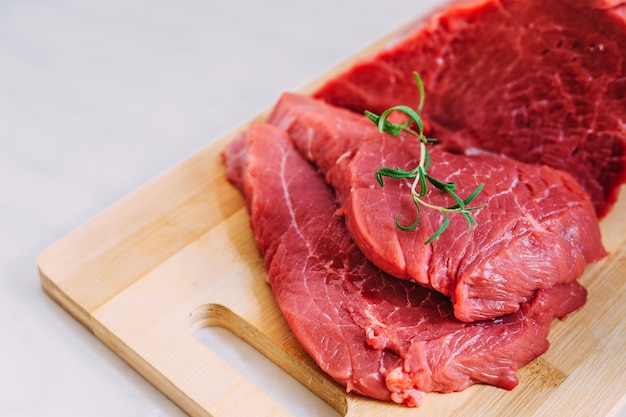 Foto filete crudo de cerdo fresco en el tablero de madera. carne de res roja sobre una tabla para cortar.