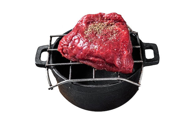 Filete crudo o bistec en una parrilla listo para cocinar aislado sobre un fondo blanco Vista superior