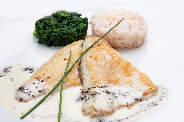 Filete de dorado con espinacas y arroz sobre fondo blanco