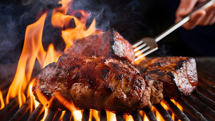 Foto un filete se está cocinando en una parrilla con un tenedor y un cuchillo