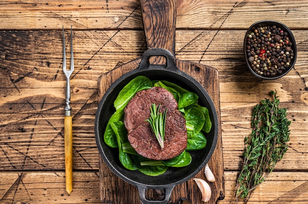 Filete frito Mignon solomillo de carne bistec de ternera en una sartén con ensalada