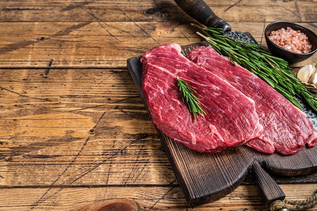 Filete de gorra cruda o bistec Picanha sobre tabla de madera con cuchillo de carnicero. fondo de madera. Vista superior. Copie el espacio.