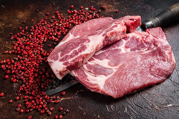 Filete de lomo de cerdo de carne de filete de cuello crudo en cuchillo de carnicero Fondo oscuro Vista superior