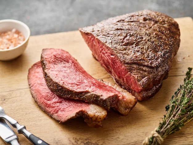 Filete de lomo en rodajas a la parrilla con sal en una tabla de cortar de madera Carne de mármol picanha brasileña