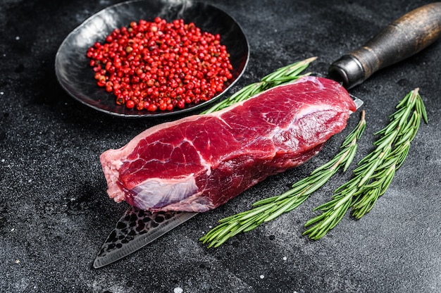 Filete de lomo de tira de carne de vacuno de mármol crudo en un cuchillo. Vista superior.