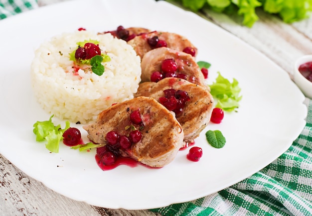 Filete de medallones de cerdo con salsa de arándanos y una guarnición de arroz