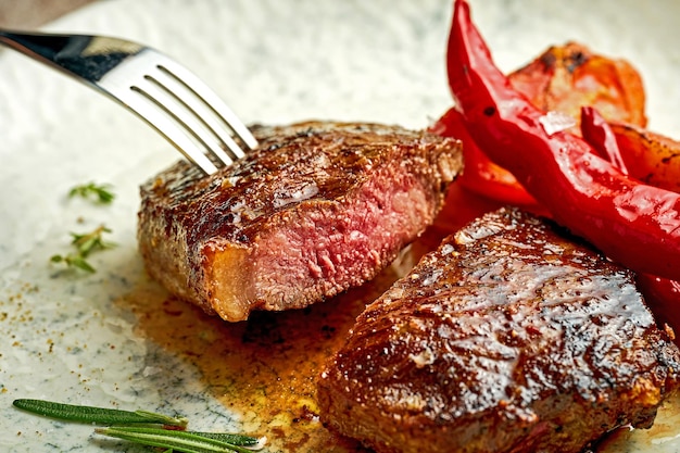 Filete medio raro en un plato blanco con especias Primer enfoque selectivo