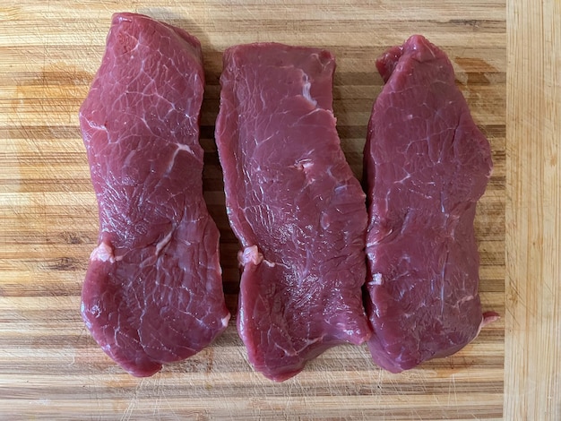 Filete de un músculo largo de carne de vacuno acostado sobre una tabla de madera